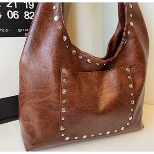 Détails du sac hobo en cuir marron vintage avec des rivets métalliques argentés