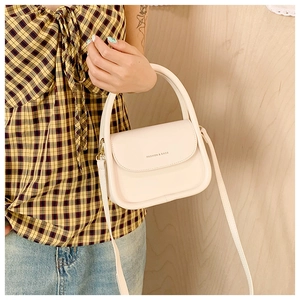 Detailed close-up of cream crossbody square bag with Fashion & Bags lettering