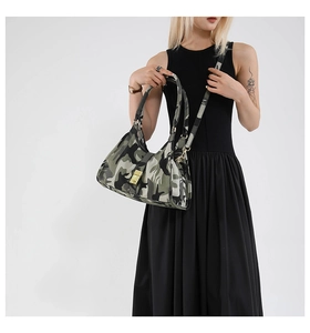 Detail of camouflage crossbody bag with gold buckle clasp and adjustable strap