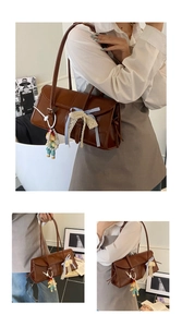 Detail of a brown glossy retro tote bag with lace bows and a cute plush keychain