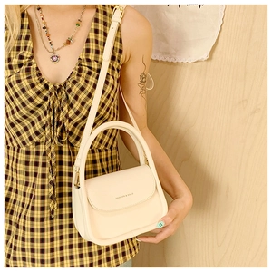 Creamy white crossbody box bag with top handle and Fashion & Bags text on the flap