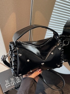 Chic black pleated barrel bag with heart studs and adjustable crossbody strap