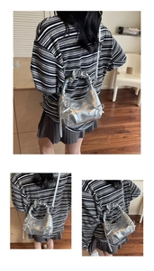 Detail of silver metallic hobo bag with bow accents and star charm on pleated handle