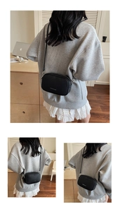 Detail of black lychee grain crossbody bag with silver hardware and adjustable strap