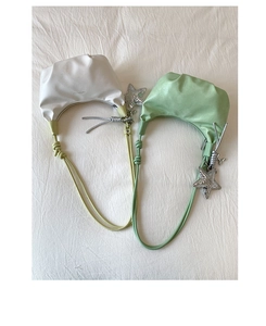 Detail of trendy pleated crescent shoulder bags in cream and mint green with star pendants