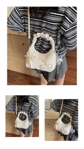 Detail of cream hobo bag featuring cloud pleats, ribbon accents and star charm