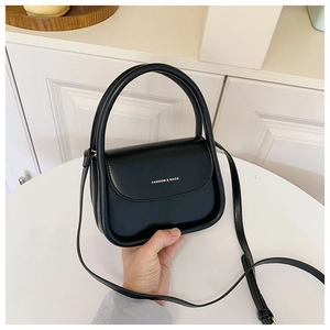 Close-up of black U-shaped crossbody bag with gold text and elegant top handle