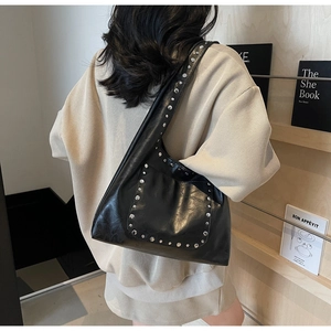Détail du sac cabas en cuir ciré noir avec rivets argentés et bandoulière épaule