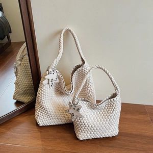 Detailed close-up of premium hand-woven cream leather tote bag with star pendant