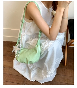 Close-up of mint green hobo bag with star pendant and knot shoulder strap detail