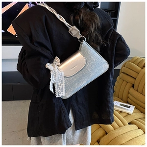 Détail du sac à paillettes bleu clair avec rabat argenté et nœud délicat en dentelle blanche