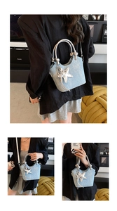 Detail of light blue denim bucket bag with silver knot handle and star charm decoration