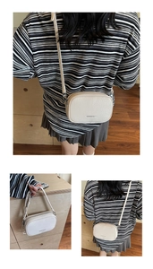Detailed view of cream square crossbody bag with litchi texture and slim strap