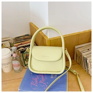 Detail of lime green PU leather small square bag with top handle and fashion text