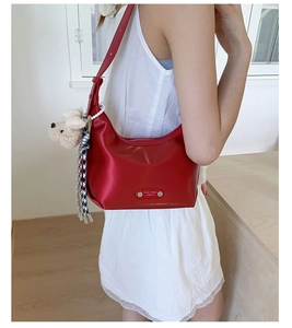 Détail du sac hobo rouge avec charm chien, foulard pied-de-poule et plaque
