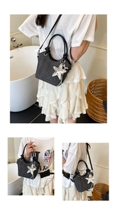 Detail of black denim bucket bag with silver glitter dots and large star tassel charm