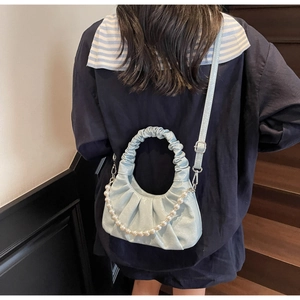 Detail of light blue ruched cloud bag with pearl chain and adjustable shoulder strap