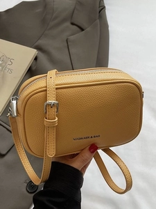 Chic mustard yellow square leather crossbody bag with silver zipper and adjustable strap