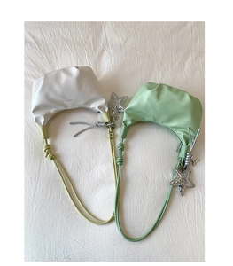 Detail of crescent dumplings bags in beige and green with silver star charms