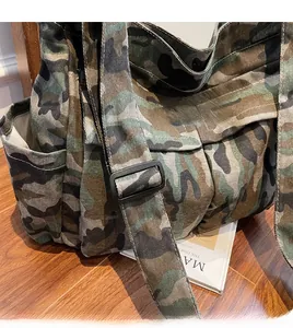Close-up of camouflage canvas tote bag with adjustable wide strap and industrial texture
