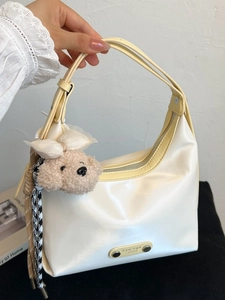 Sac hobo minimaliste beige avec bandoulière jaune et breloque ours décorative