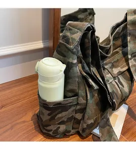 Detail of camouflaged messenger bag featuring a side pocket for water bottle storage