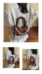 Detail of brown pleated cloud bag featuring pearl chain strap and glossy finish