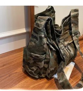 Detail of durable camouflage canvas crossbody bag with large side pocket for extra storage
