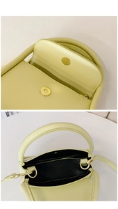 Macro detail of magnetic closure and black interior lining of the yellow leather handbag