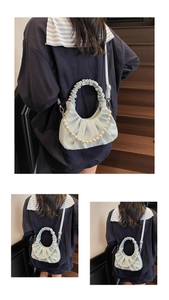 Detail view of light blue pleated bag featuring large pearl chain and soft PU leather