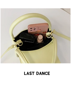 Top view of pale green mini handbag showing interior storage for phone and makeup