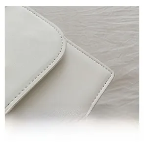 Close-up of precise stitching on white leather bag highlighting expert craftsmanship