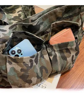 Close-up of camouflage canvas tote showing exterior utility pockets and storage capacity