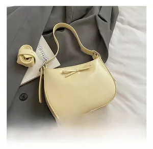 Détail du sac à bandoulière crème avec nœud décoratif et bandoulière amovible