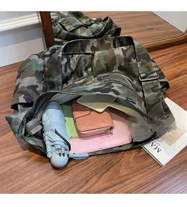 Detailed interior of large camouflage canvas crossbody bag showing spacious storage capacity