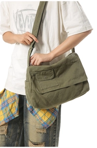 Detail of army green canvas messenger bag with flap cover and adjustable strap for men and women