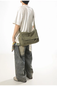 Detail of army green canvas messenger bag featuring large flap and functional side pocket