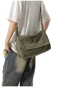 Close-up of military green canvas crossbody bag showing texture and metal buckle detail