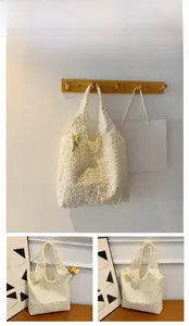 Detailed embroidery on white lace tote bag with a small 3D floral charm accessory