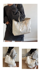 Dettaglio della borsa tote crema con stampa a farfalla, pizzo e ciondolo di perle eleganti