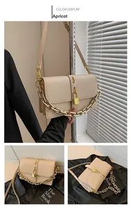 Detail of apricot messenger bag with thick gold chain and padlock hardware accent