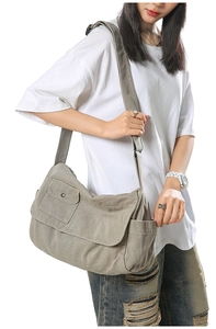 Large khaki canvas crossbody bag detail showing front snap pocket and adjustable strap