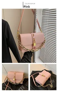 Detail view of pink flap bag with chunky gold chain strap and decorative gold lock