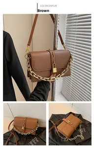Detail view of brown chain crossbody bag with gold lock and multi-layer interior