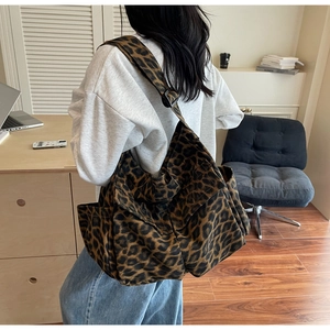 Detailed view of leopard print canvas bag with adjustable black shoulder strap and pocket