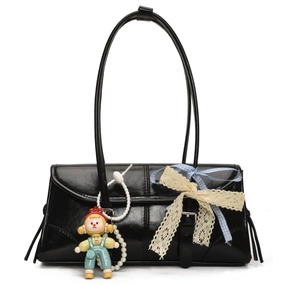 Detail of black faux leather tote bag with lace bow, pearl chain and cute charms