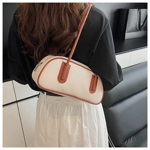Detail of canvas bowling bag with brown leather trim and metal zipper on model shoulder