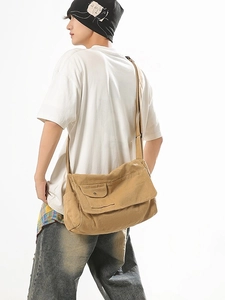 Large khaki canvas messenger bag with flap cover and side pocket on male model