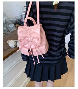 Detailed back view of a pink glossy bow backpack with drawstring and adjustable straps