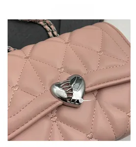 Détail du sac à main rose matelassé avec broderie cœur et fermoir cœur en métal argenté
